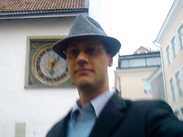In front of a cool old clock onthe curch at the square in the midle of old town